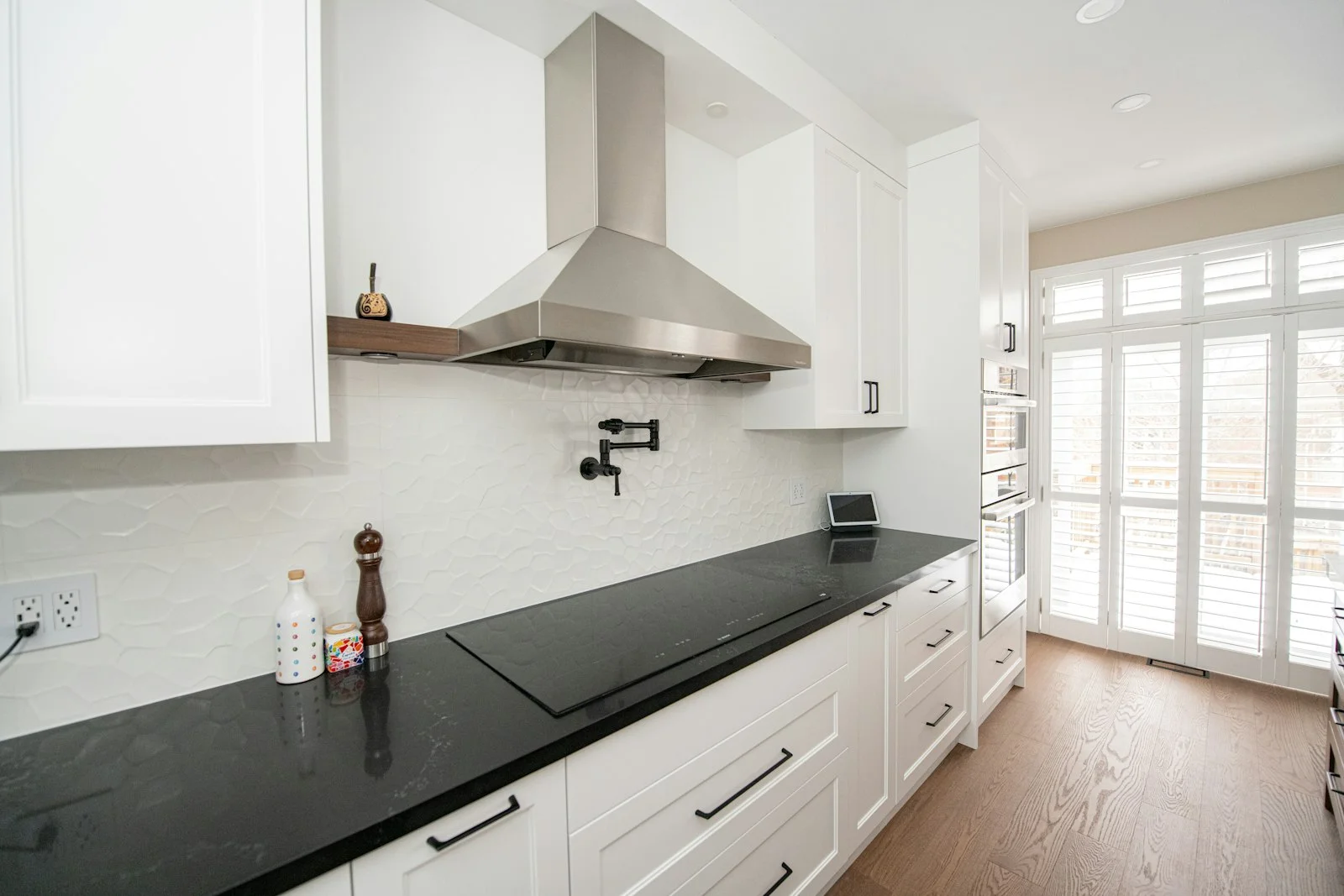 Modern kitchen with white shaker cabinets, subway tile backsplash and brass hardware
